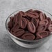 A glass bowl of Valrhona Caraibe dark chocolate feves.