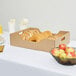 A table with a catering tray of donuts and apples.