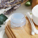 A clear container with a round lid filled with white round objects.