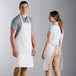 A man and woman wearing white Choice aprons with pockets.