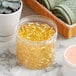 A clear container of yellow pills next to a basket of towels.