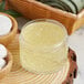 A clear jar of gel on a wood surface.