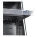 A shelf with a clear plastic tray in a Avantco vertical air curtain merchandiser.
