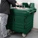 A man using a green Cambro portable hand sink on a counter.