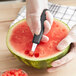 A person using a Mercer Culinary melon baller to make watermelon balls.