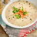 A bowl of Chef Francisco Wild and Brown Rice with Chicken Soup garnished with carrots and parsley.