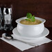 A bowl of Silver Skillet cream of chicken soup on a table with a spoon and a napkin.