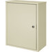 A beige metal Omnimed wall-mount storage cabinet with a door and key lock.