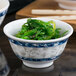 A blue Thunder Group melamine rice bowl filled with seaweed on a table in an Asian cuisine restaurant.