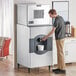 A man using a Scotsman ice dispenser to pour water into a rectangular machine.