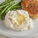 A plate of food with Honest Earth Rustic Mashed Potatoes, green beans, and a piece of meat.