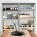 An AR Shelving galvanized metal bolted shelving unit with shelves holding plates and bowls in a farm-to-table restaurant.