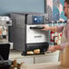 A man using a Solwave countertop rapid cook oven to prepare food.