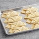 A gray tray of LeCoq Cuisine ready to bake ham and cheese croissants on a counter.