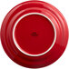 A red Tuxton Concentrix china plate with a white rim.