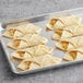 A tray with several LeCoq Cuisine ready to bake bacon and egg croissants on a gray surface.