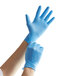 A person wearing blue Showa nitrile gloves.