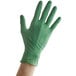 A hand wearing a green Showa biodegradable nitrile glove.