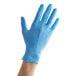 A hand wearing a Showa blue nitrile glove.