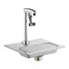 A silver Regency glass filler station with a faucet over a stainless steel sink.