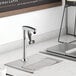 A Regency glass filler station with an 8" glass filler on a stainless steel table.