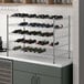 A Regency chrome wire wine rack with bottles on it.