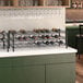 A Regency black epoxy wire wine rack on a green counter.