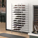 A Regency chrome wire wine rack with bottles of wine on it.