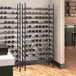 A Regency black wire wine rack filled with wine bottles.