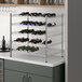 A Regency chrome wire wine rack with bottles on it.