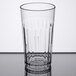 A Carlisle clear plastic tumbler on a white table.