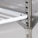 A close-up of a metal shelf with a white rack.