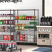 A Steelton wire shelving kit with black shelves and posts holding beverages.