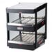 A black Nemco countertop food warmer with double shelves on a bakery counter.