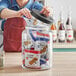 A woman using an Acopa Dusk glass jar to store cookies.