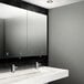 A white bathroom with a Velare stainless steel hand dryer above a white sink with a silver faucet.