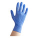 A hand wearing a blue Noble NexGen nitrile glove.