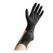 A person wearing black Noble NexGen Nitrile gloves.