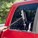 A hand using a Lavex window squeegee to clean a car window.