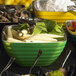 A group of Vollrath green apple metal serving bowls on a hotel buffet table.