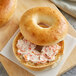 An Original Bagel with cream cheese on a wooden board.