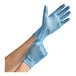 A person's hands wearing small blue vinyl gloves.