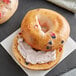 A New York style bagel with blueberries and cream cheese on top.
