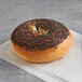 An Original Bagel New York Style bagel with poppy seeds on top.