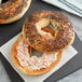 A frozen Original Bagel with cream cheese and black poppy seeds on a white background.