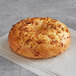 An Original Bagel with cheese and pepper on top.