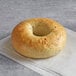 An Original Bagel New York Style Spinach Bagel with a hole in the middle on a napkin.