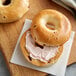 A New York style cranberry bagel with cream cheese spread on it.