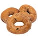 A close-up of a Original Bagel cinnamon raisin bagel with raisins on top.