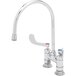 A chrome T&S deck-mount faucet with gooseneck spout and wrist action handles, including a red and blue handle.